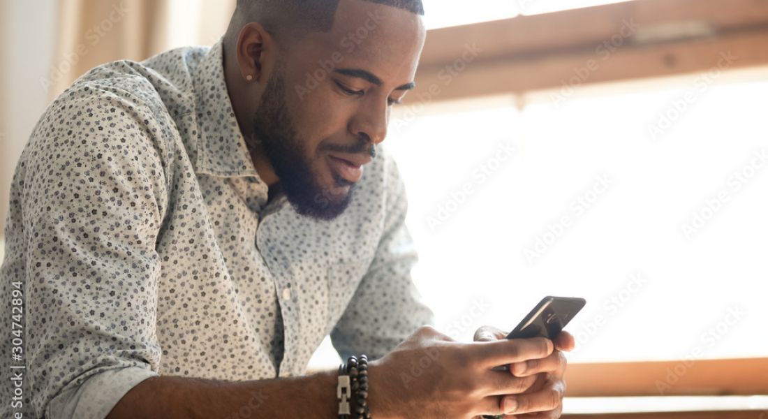 A man holding a smartphone with smart home screen