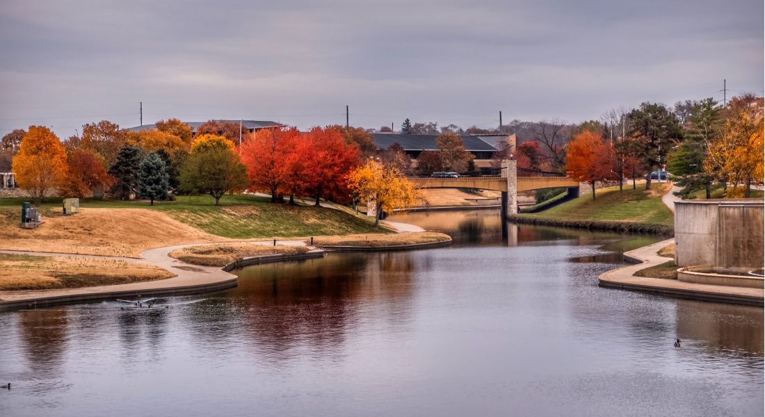 River in Kansas City  with surrounding park covered in trees turning vibrant autumn colors