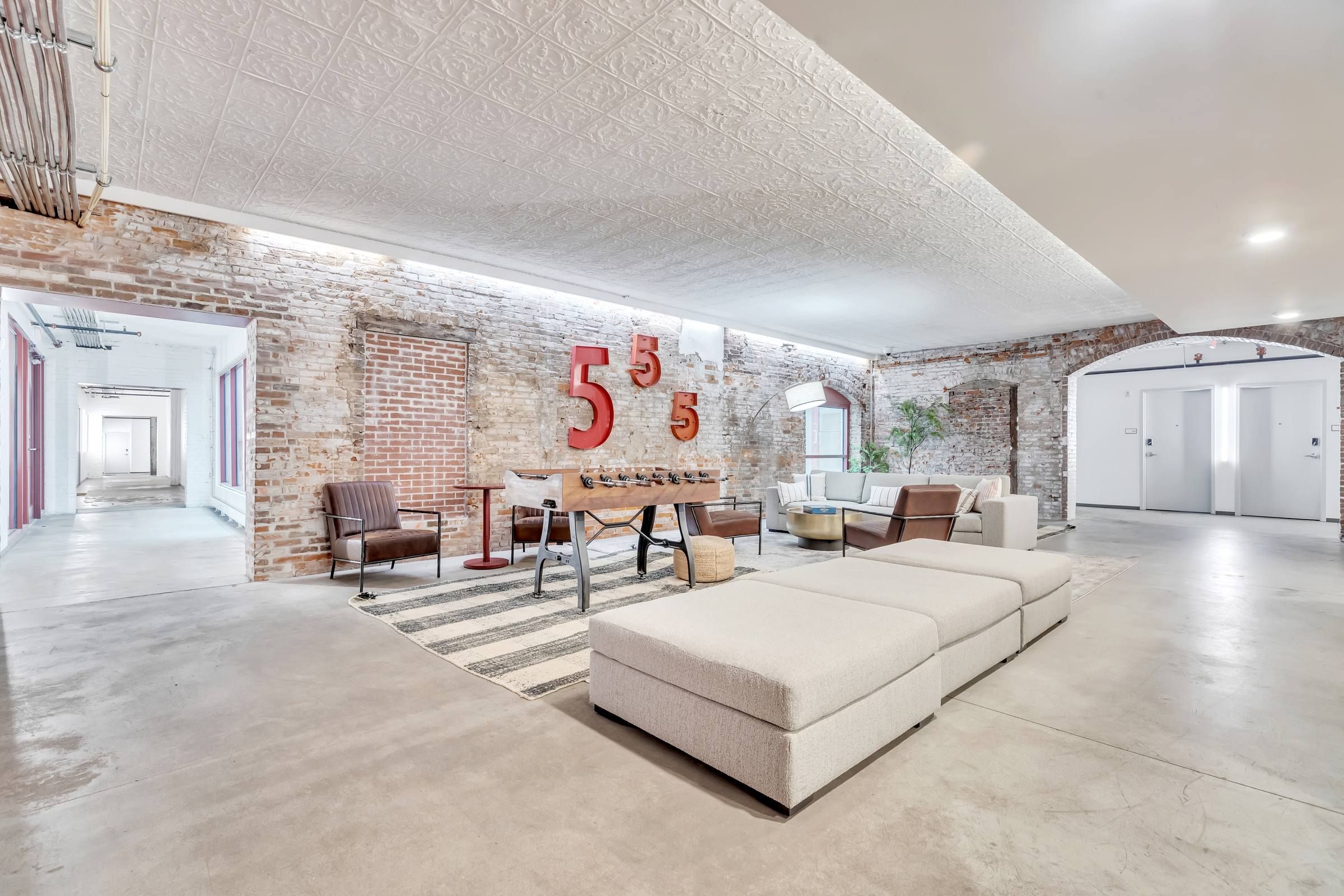 West Bottoms Flats apartment lobby featuring painted brick walls, cement floors, and modern furniture