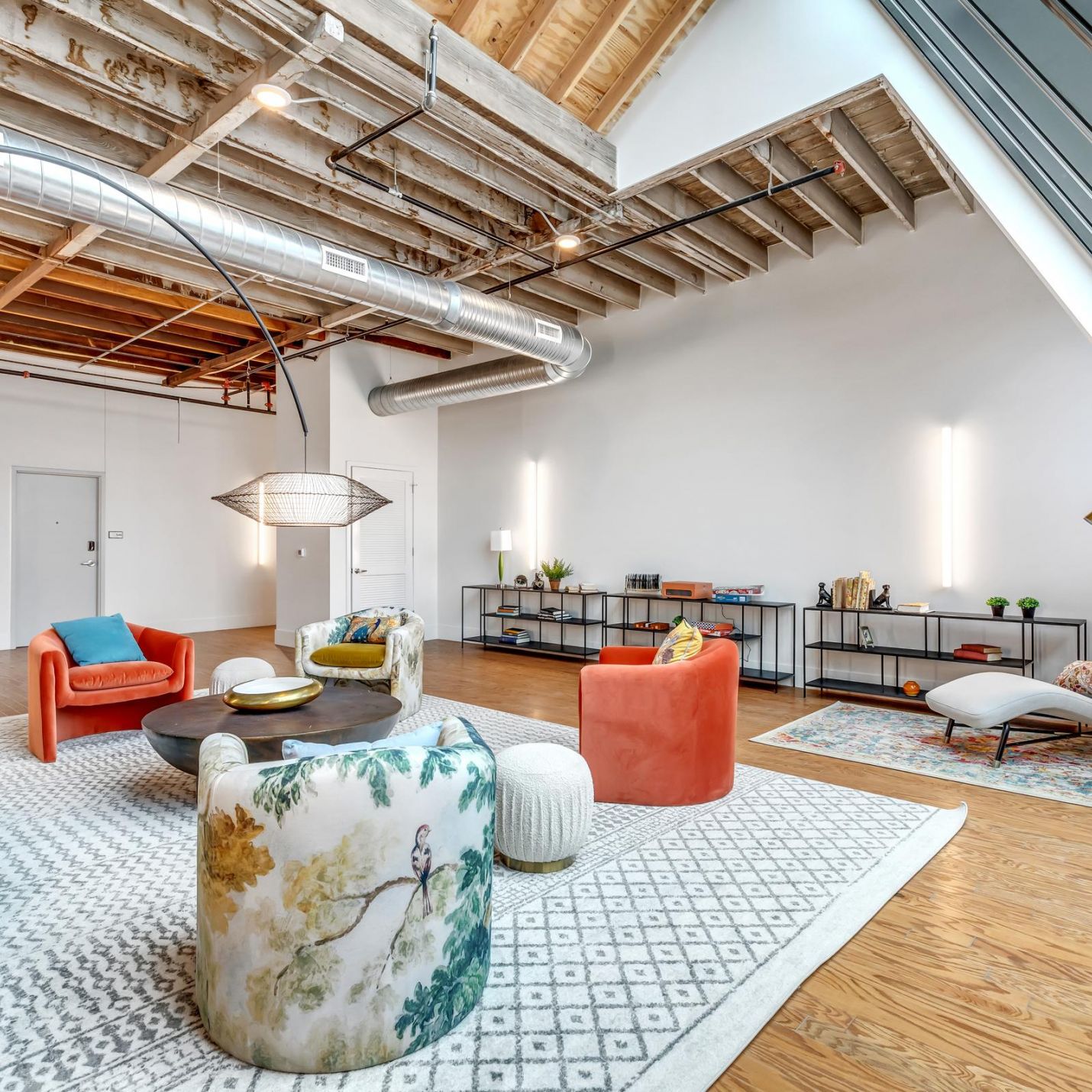 West Bottoms Flats apartments resident lounge with urban core features like raft ceilings, wood flooring, and modern furniture