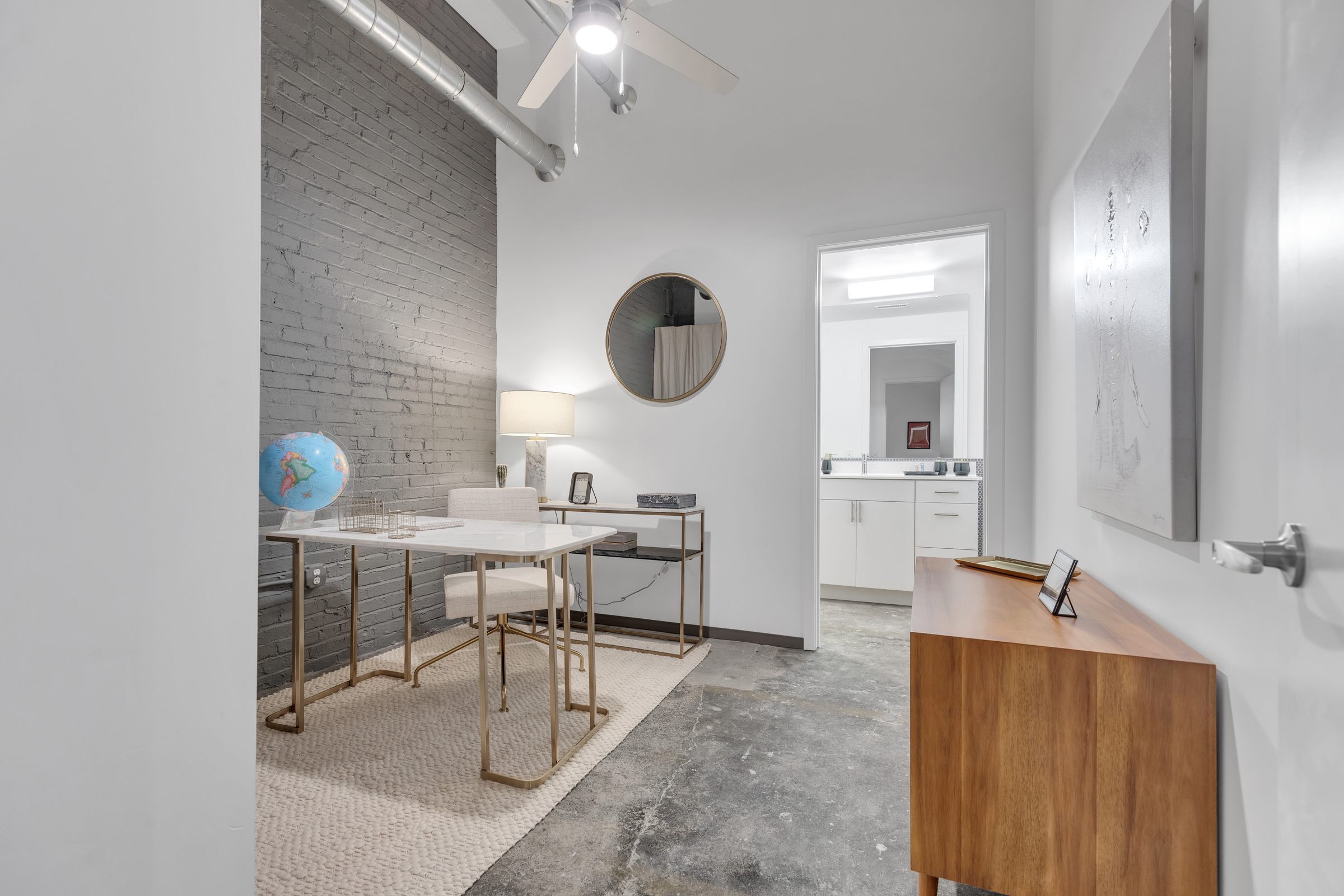 West Bottoms Flats apartment office room with cement floors and high ceilings and filled with office furniture