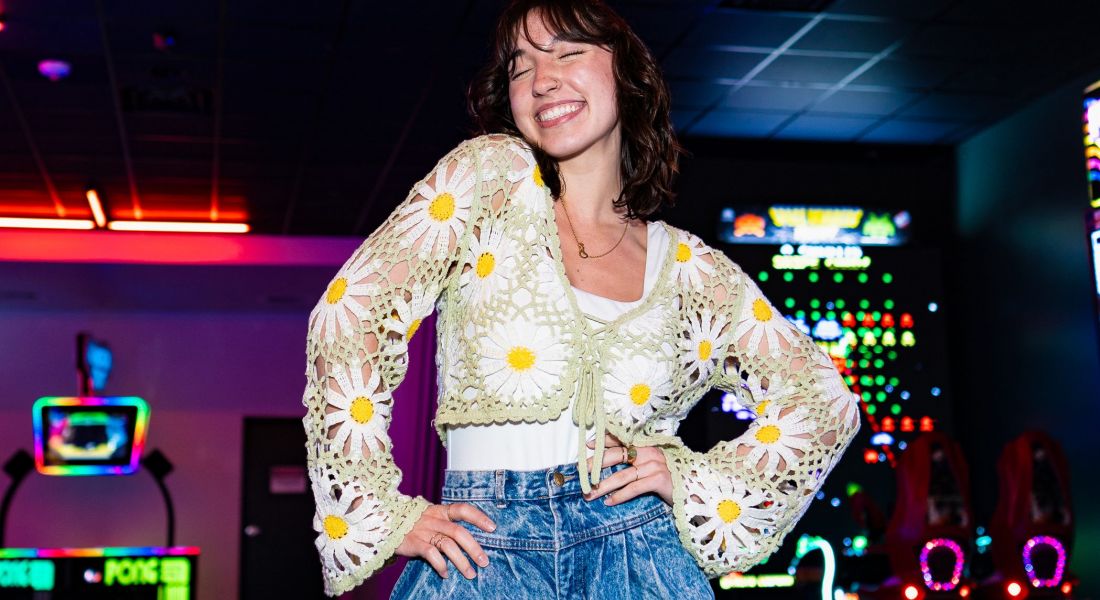 Young woman smiling in crochet top inside of Larks located near West Bottoms Flats