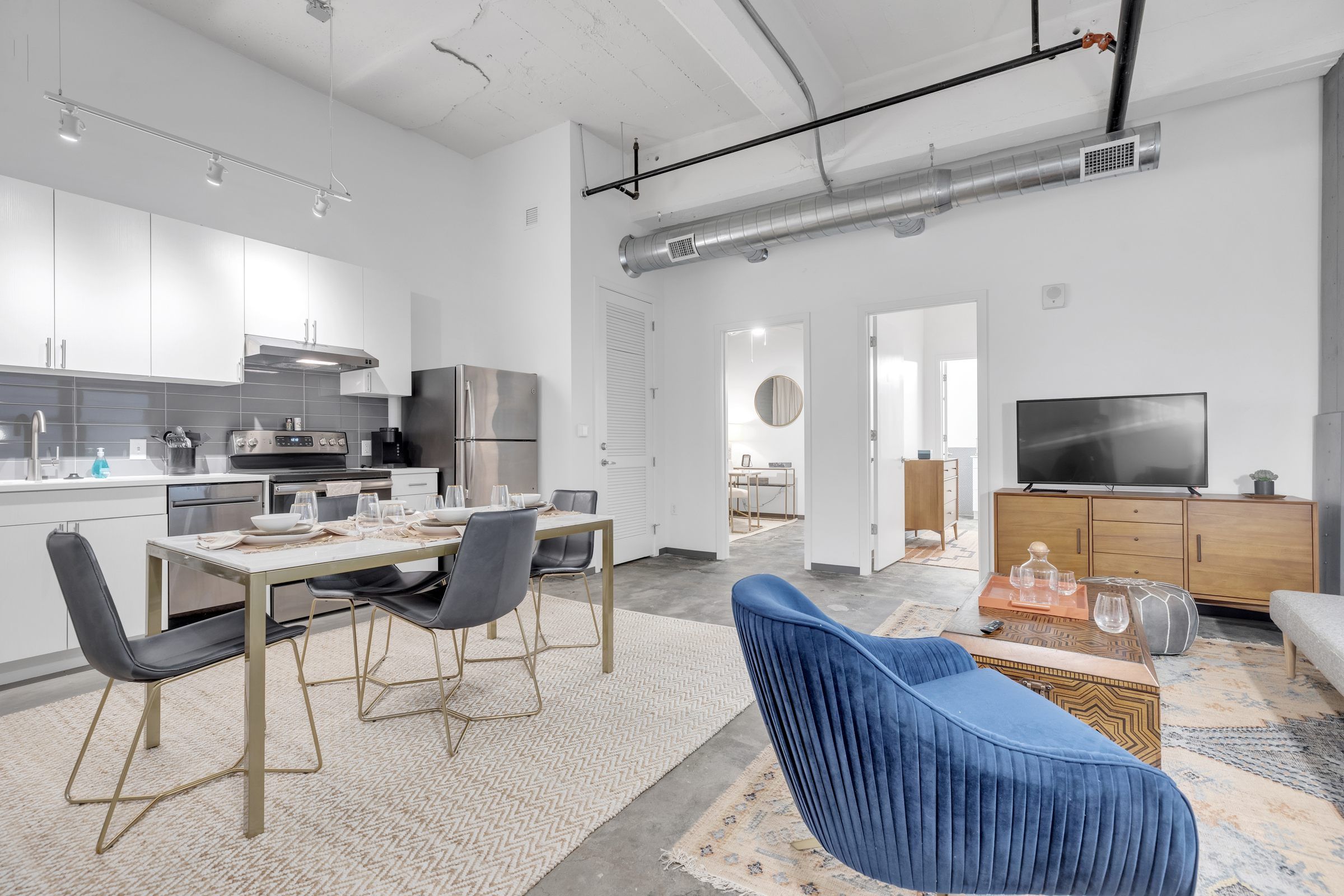 West Bottoms Flats apartment living room open floor plan with high ceilings and cement floors, featuring modern furniture