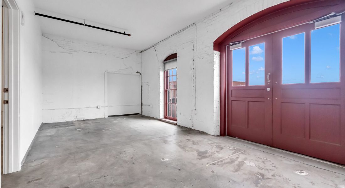 West Bottoms Flats apartment living room with open floor plan and urban core features like high ceilings, large arched factory windows and original cement windows