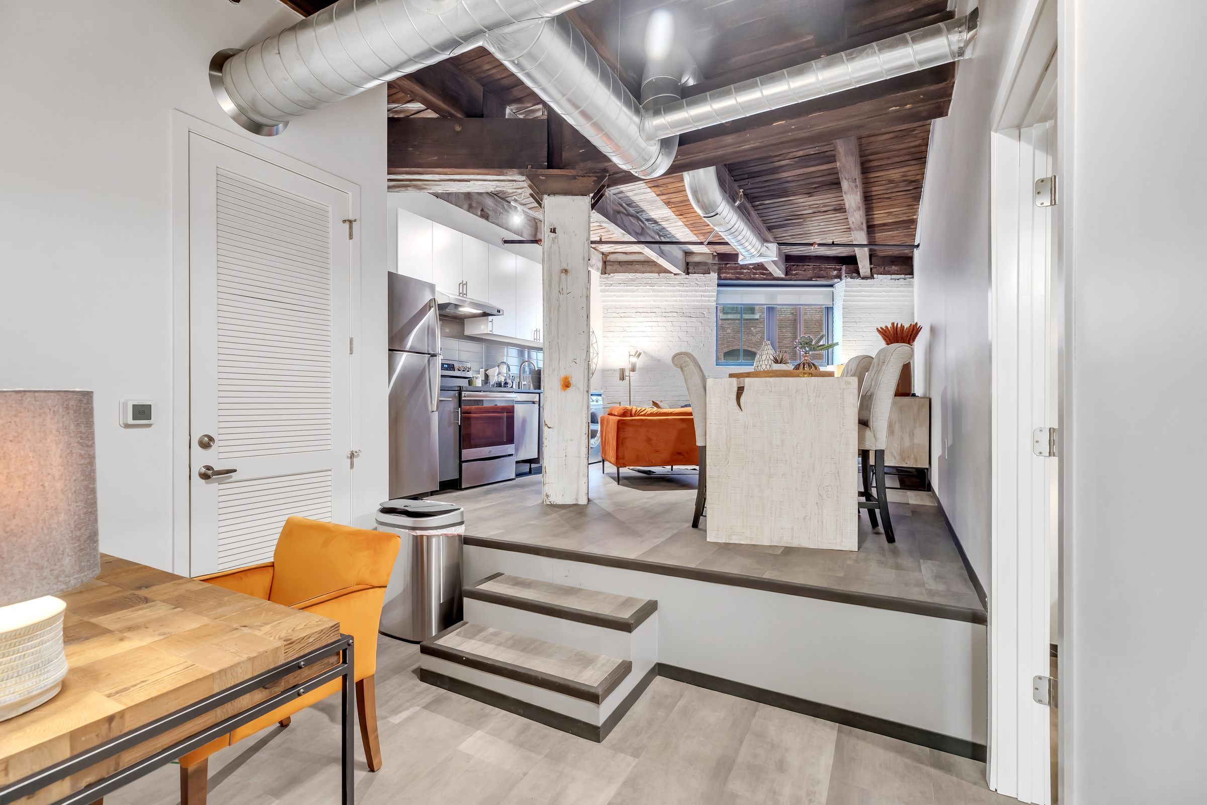 West Bottoms Flats apartment living room with urban core features like raft ceilings, cememt flooring, large windows and modern furniture