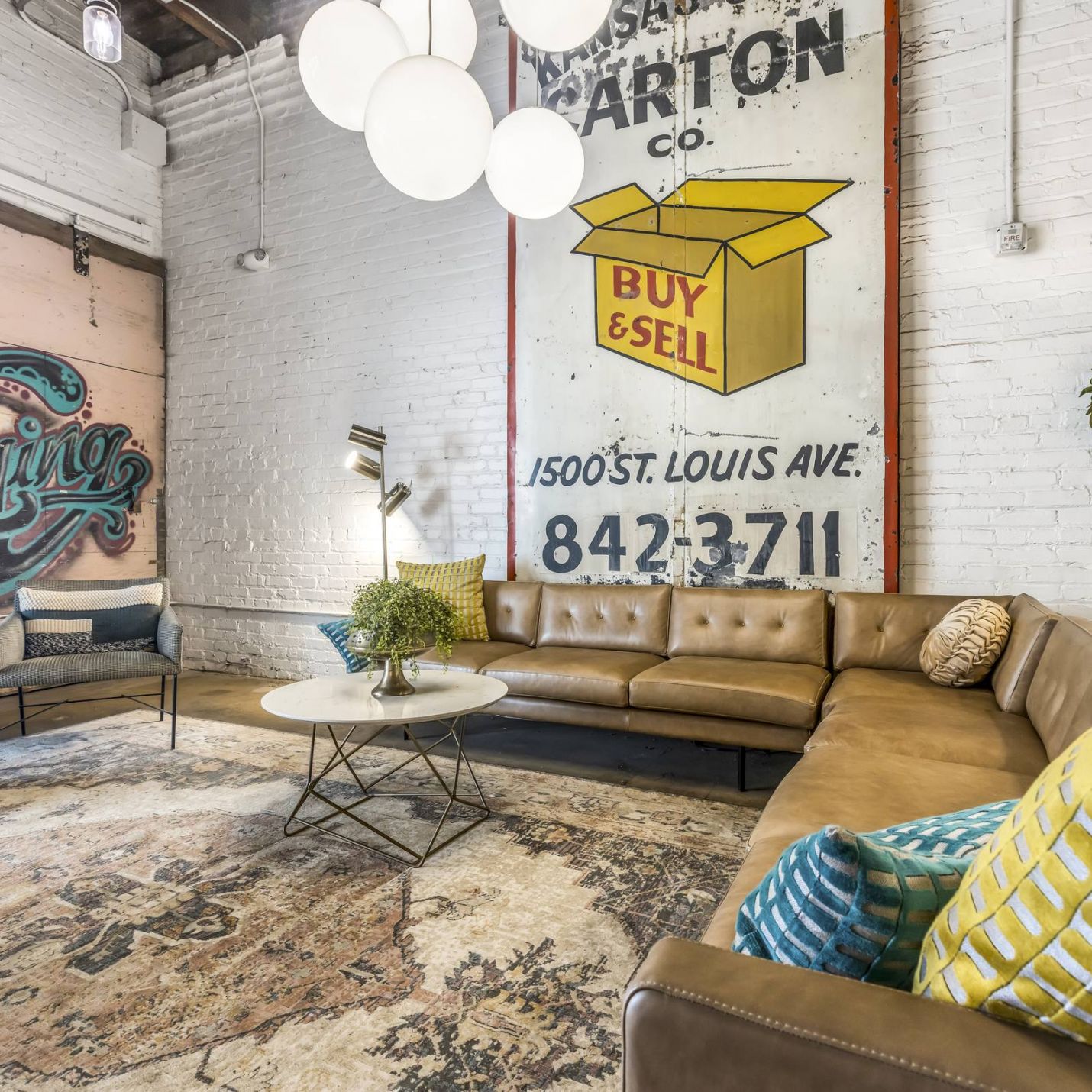 West Bottoms Flats apartments resident lounge with urban core features like exposed brick walls, concrete floors, and high ceilings 