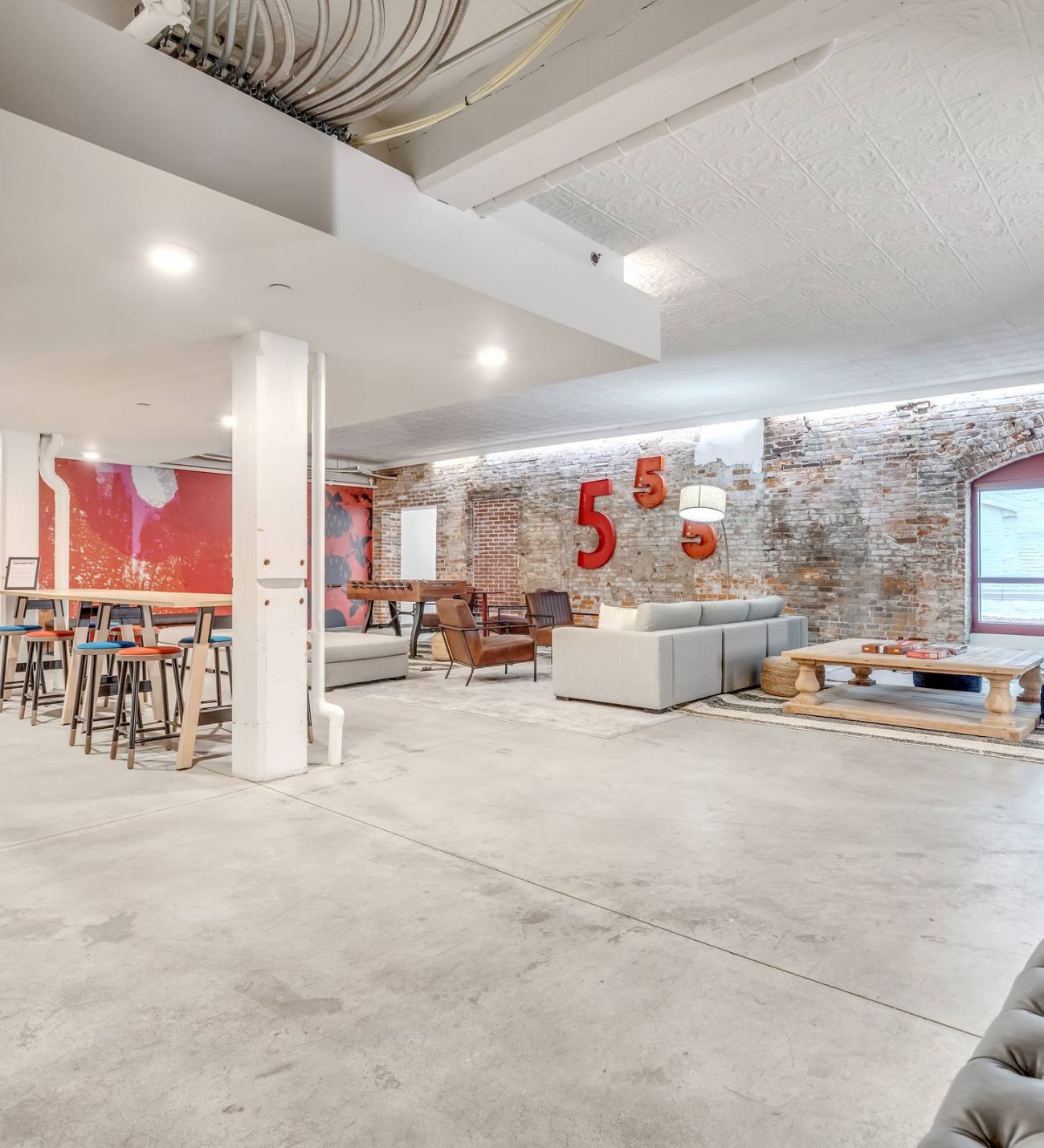 West Bottoms Flats apartments resident lounge with urban core features like exposed brick walls, concrete floors, and high ceilings